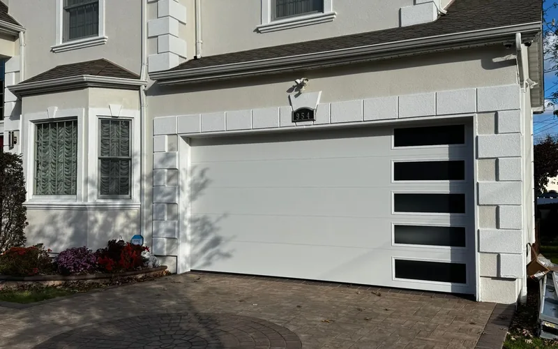 Modern flush panel garage door with vertical glass accent installed by Eagle Garage Door Services in Maryland